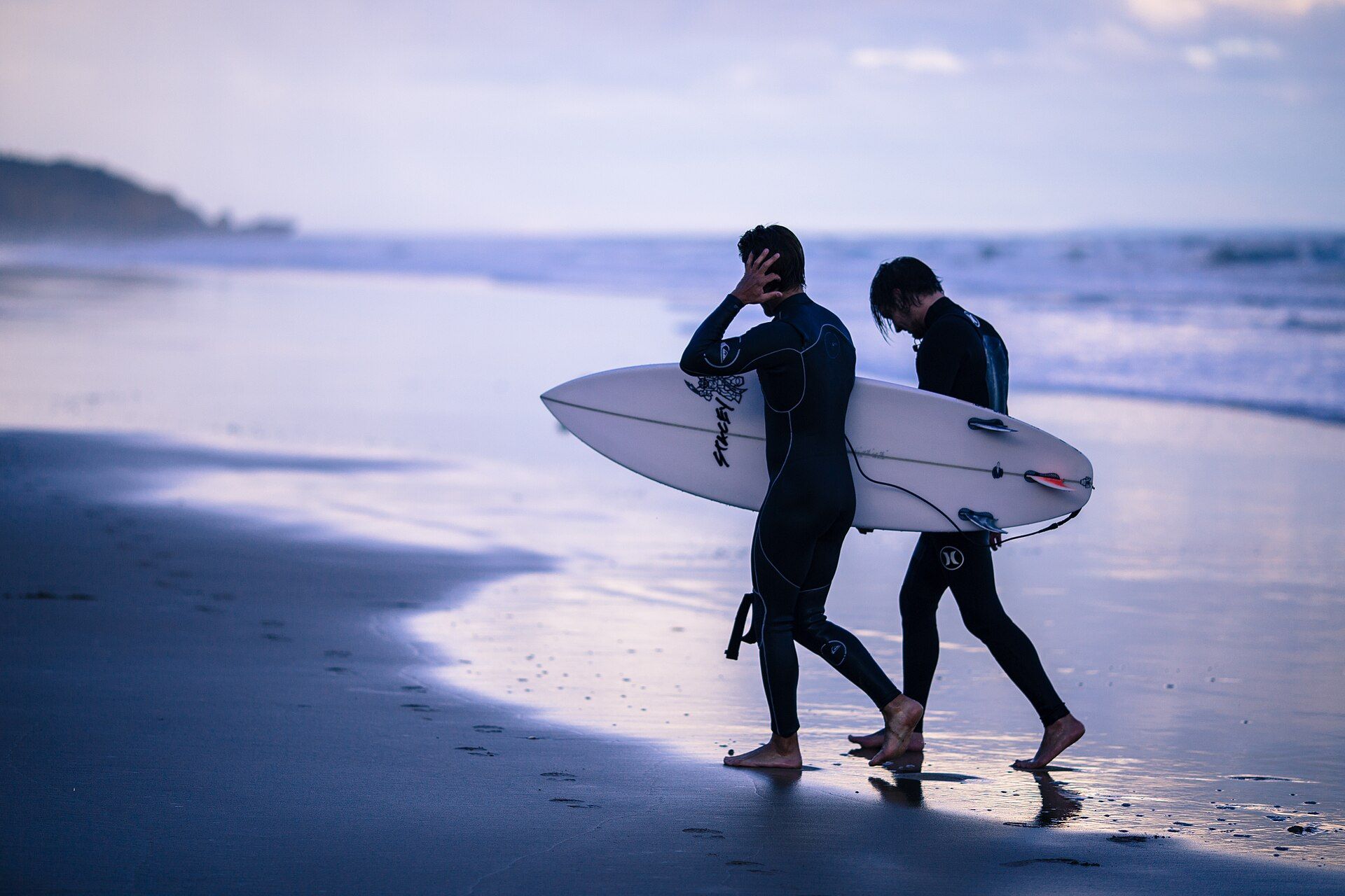 Surfers walking along the beach at Torquay on Victoria's Surf Coast
